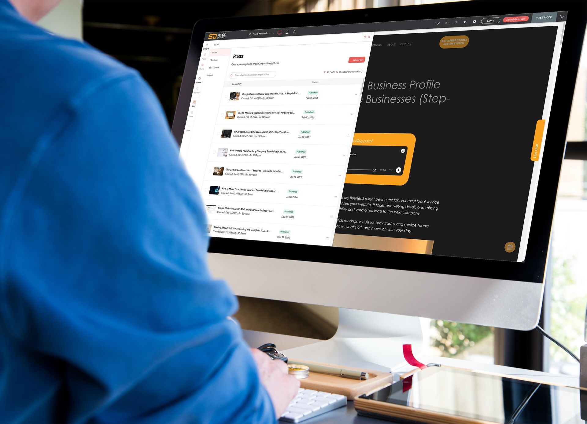 A person viewing a website with a dark and gold design on a computer screen.