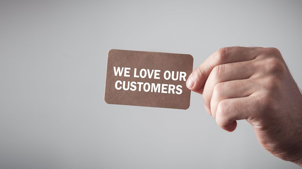 Hand holding a brown card that says