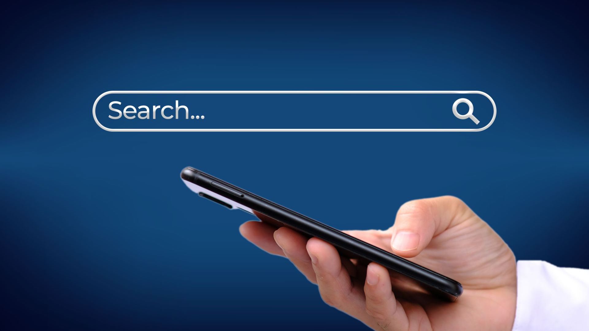 A person is holding a cell phone with a search bar on the screen.