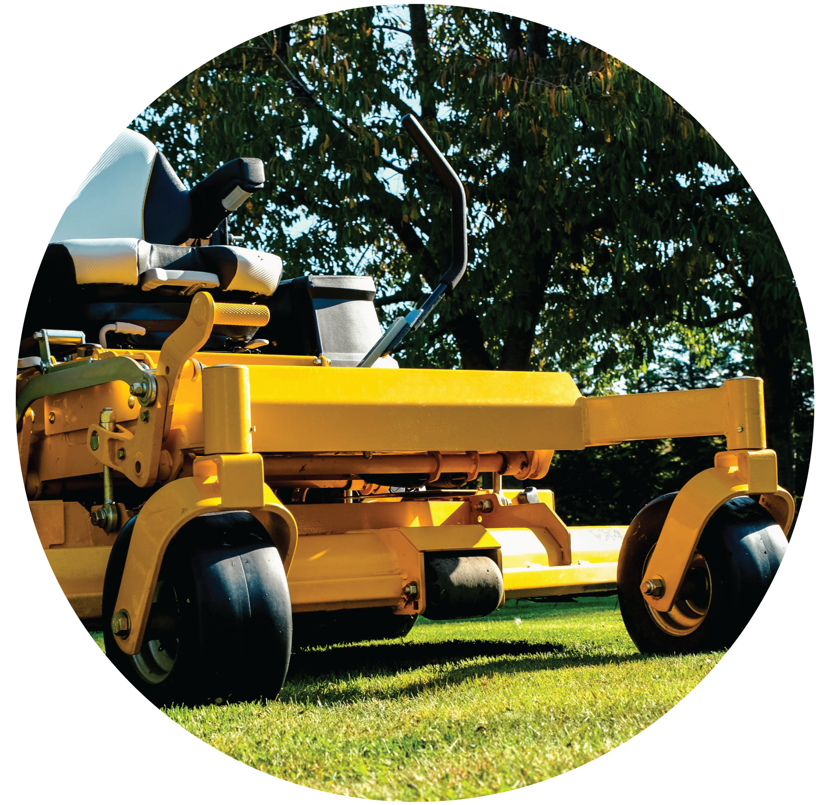 a yellow lawn mower is parked on a lush green field