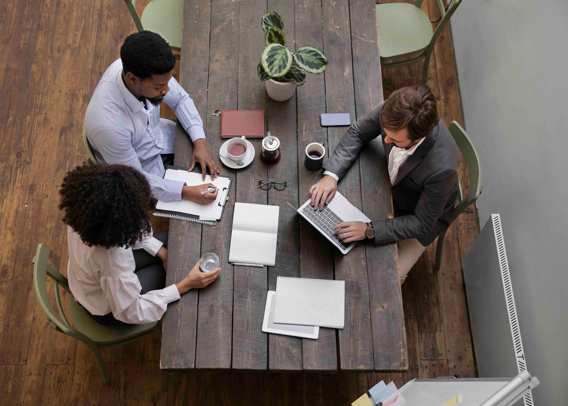 Photo by Freepik A group of people are sitting around a wooden table.