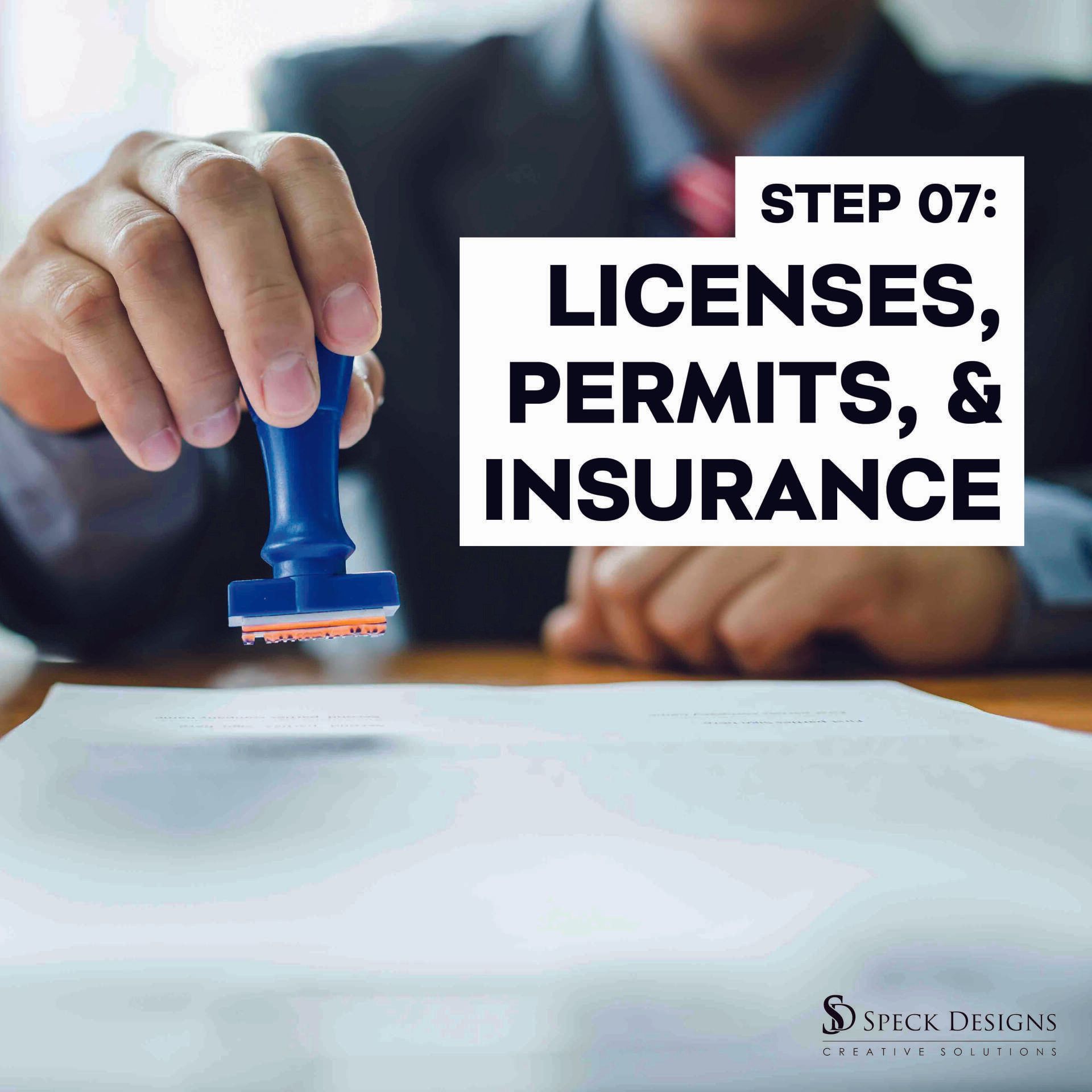A man is stamping a piece of paper with a stamp that says licenses permits and insurance