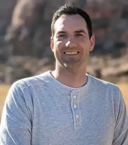 Steven, the owner of Speck Designs in front of mountains.