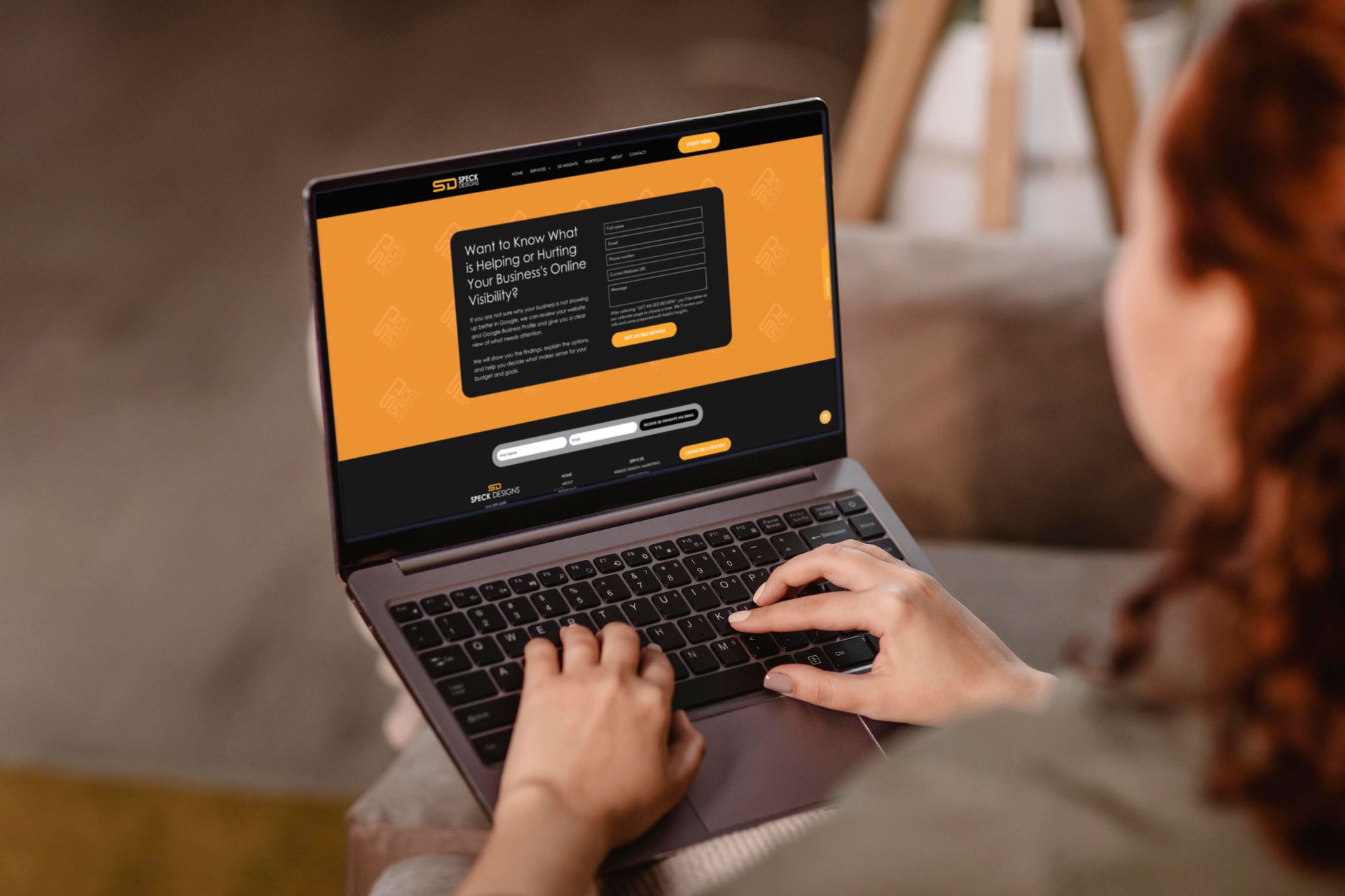 Person typing on a laptop with a code editor open on a desk indoors