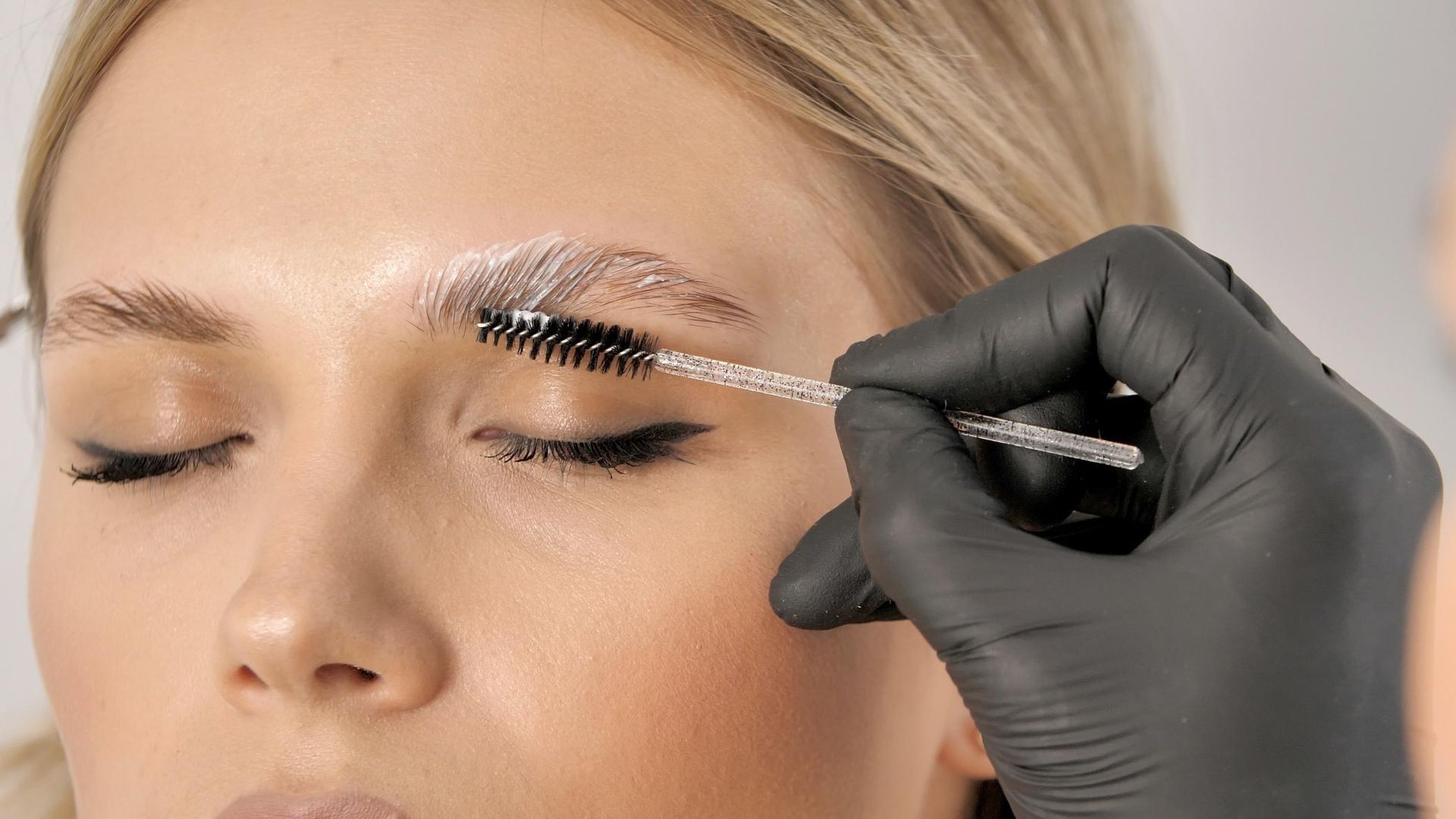 A Woman is Getting Her Eyebrows Painted by a Makeup Artist — Xtreme Rejuvenation Clinic, Medispa & Beauty Therapy In Maryborough, QLD