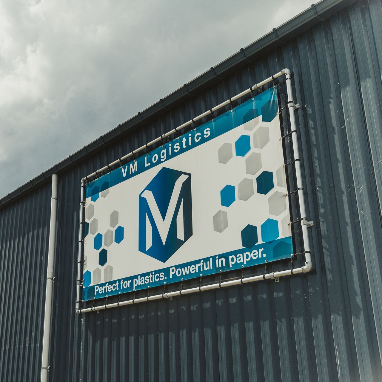 Een bord voor vm logistics hangt aan de zijkant van een gebouw