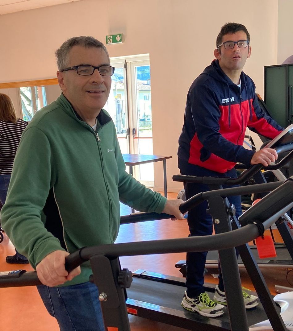 Due uomini corrono sui tapis roulant in una palestra