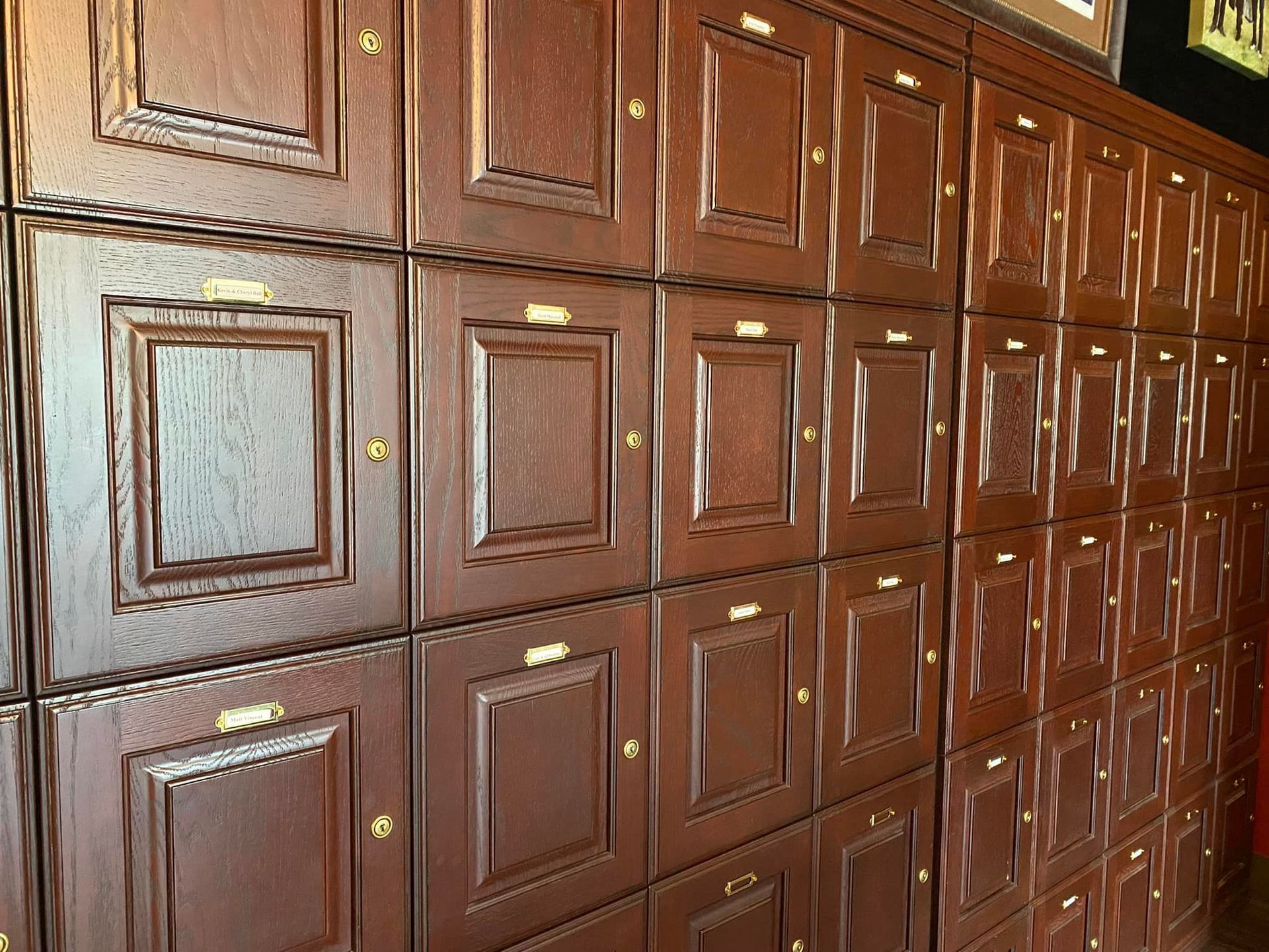 A wall of wooden cabinets with square doors and drawers.