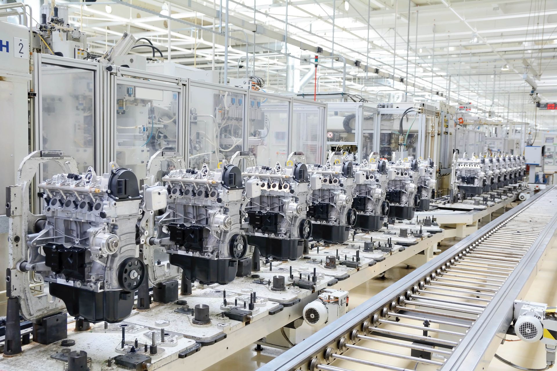 A row of engines sitting on top of a conveyor belt in a factory
