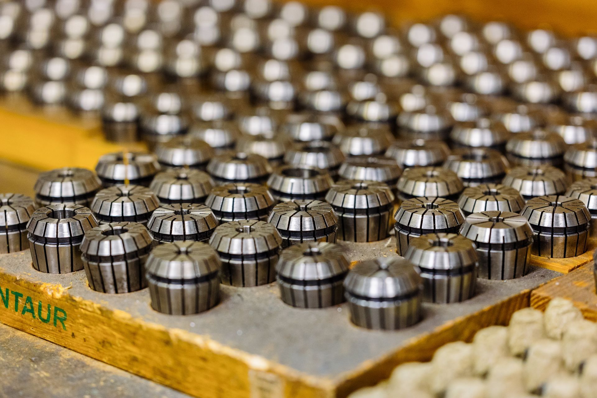 A bunch of collet chucks are sitting on top of a wooden table.