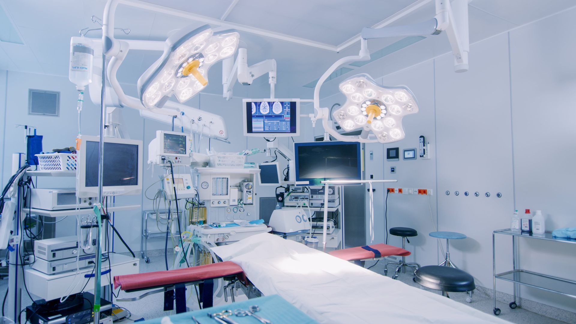 An empty operating room in a hospital with lots of medical equipment.
