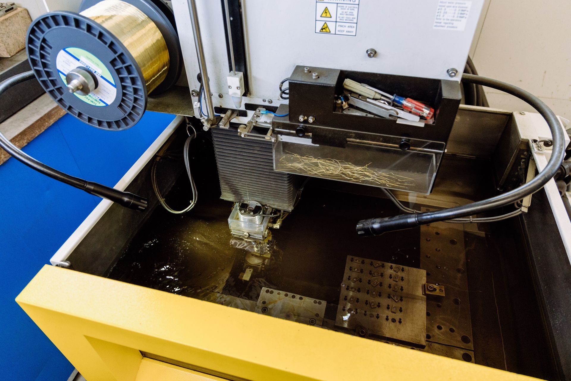 A machine is cutting a piece of metal in a factory.