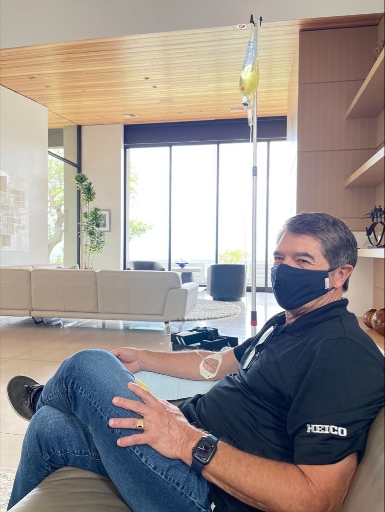 Patient receiving home IV therapy while relaxing on a sofa.