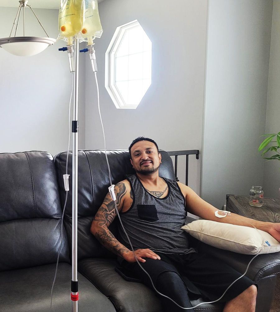 Man on with tattoos having IV therapy drip at home