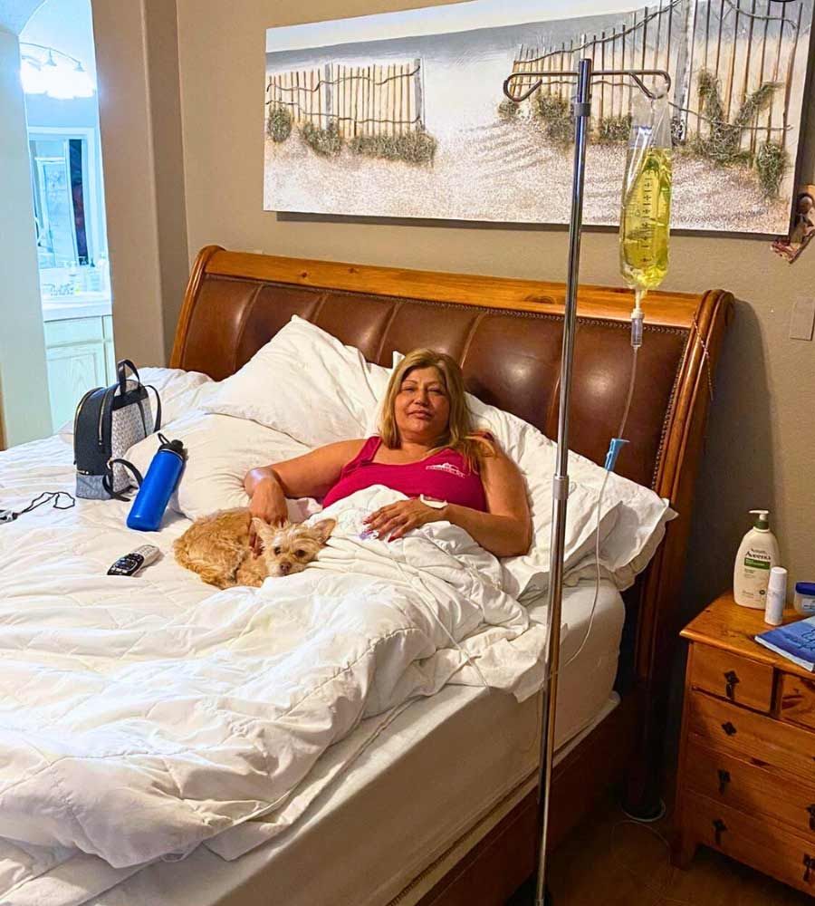 Woman receiving weight loss support IV therapy at home.