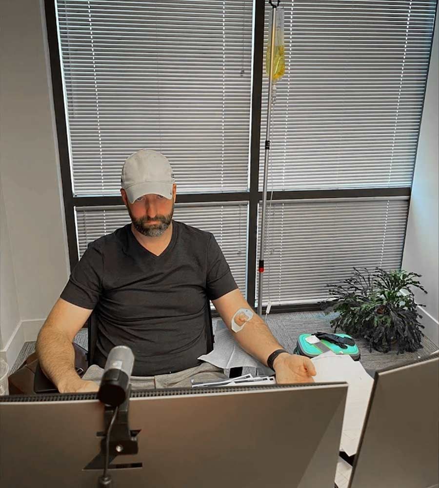 Man receiving mobile IV therapy energy boost at home office