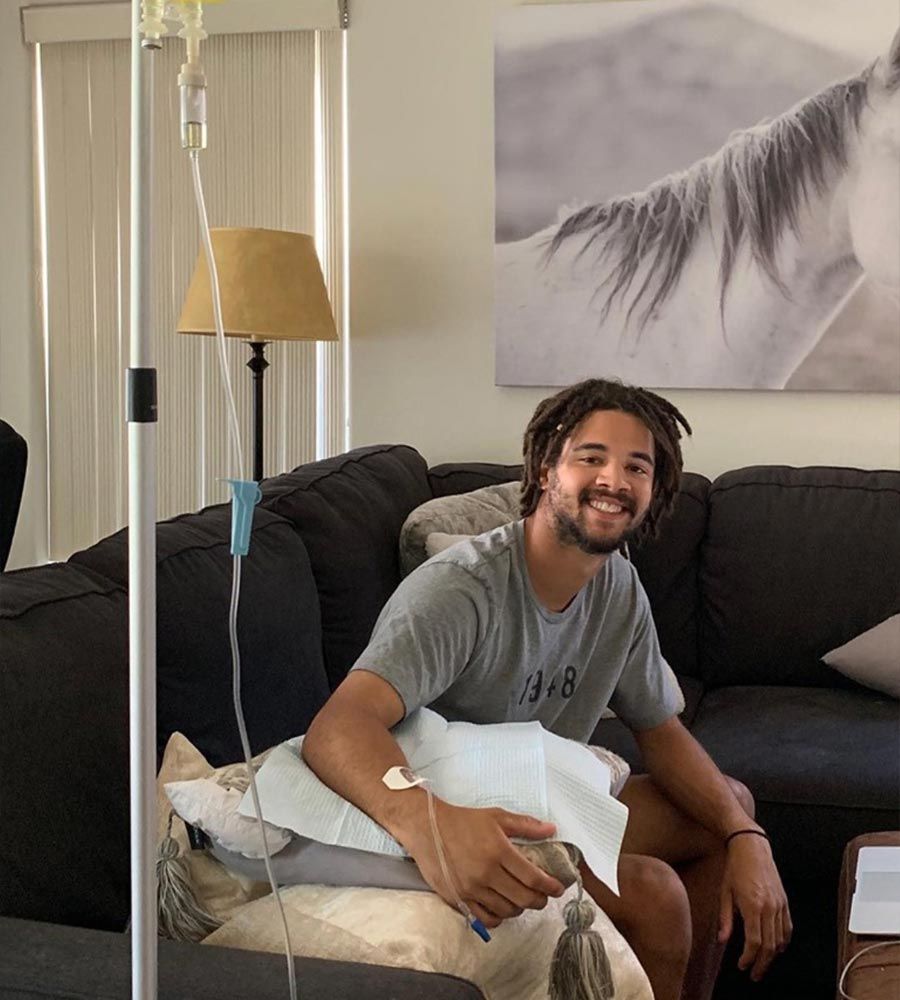 Man receiving pain management IV therapy at home for back pain