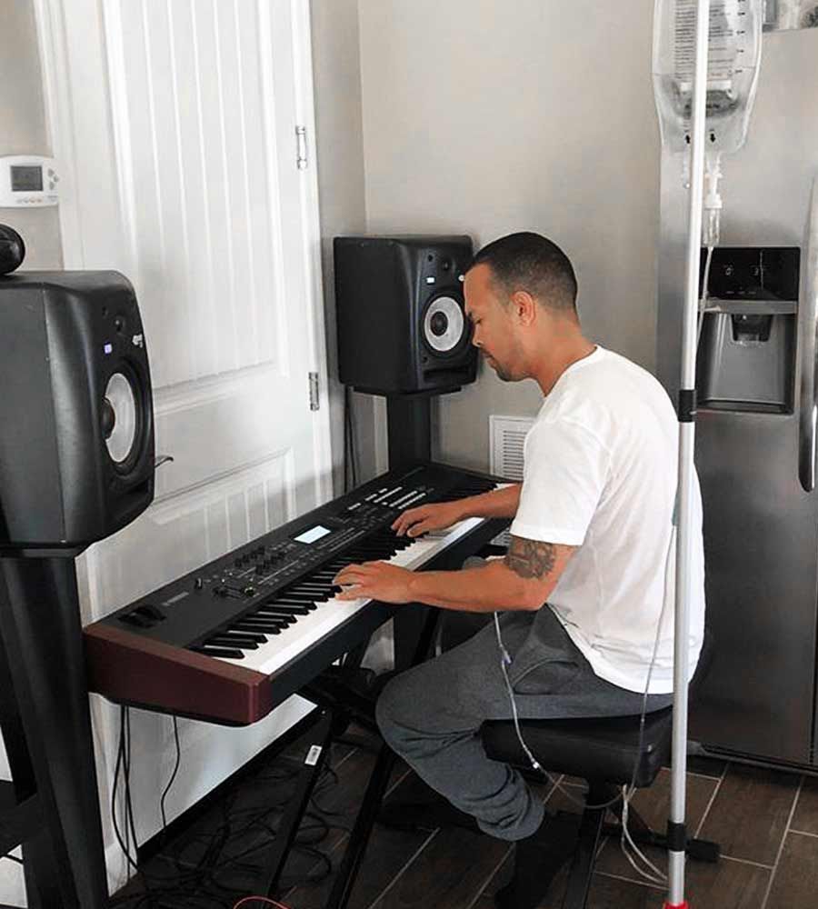 Musician playing keyboard while getting at-home IV drip.
