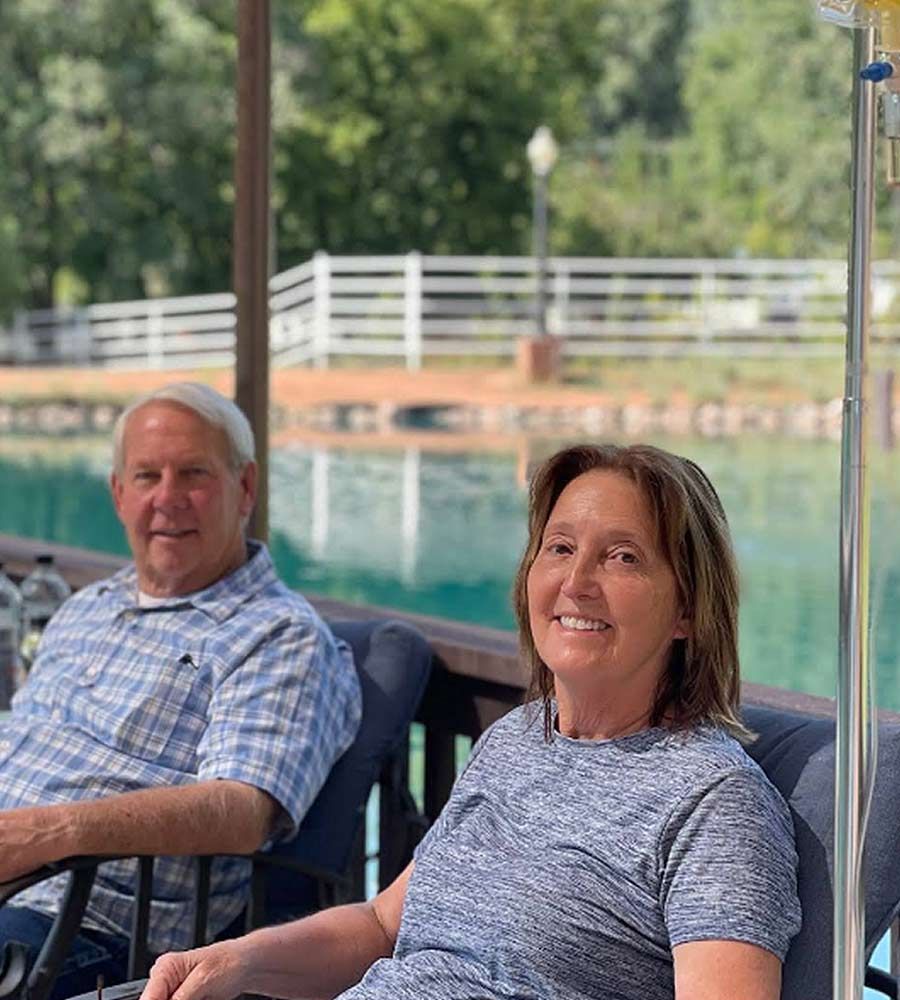 Sunburned man and woman receiving sunburn IV therapy at hotel pool