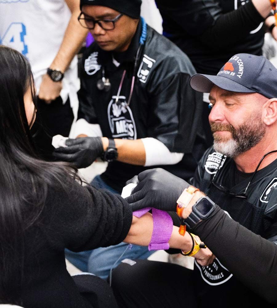 Medical professional preparing a patient for IV therapy with a tourniquet.