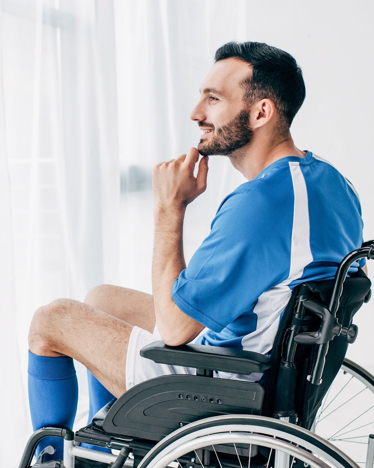 Smiling male athlete sitting in wheelchair.