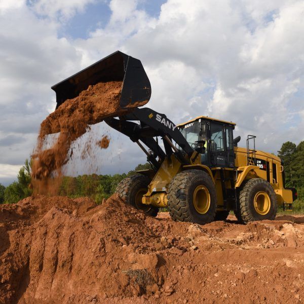 A sany bulldozer is pouring dirt into a pile
