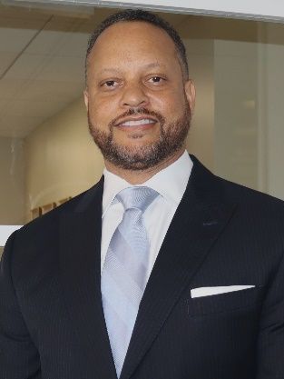 A man in a suit and tie is smiling for the camera.