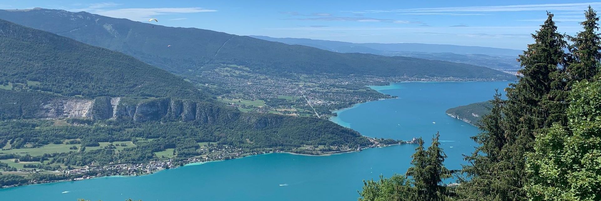 Une grande étendue d'eau entourée de montagnes et d'arbres.