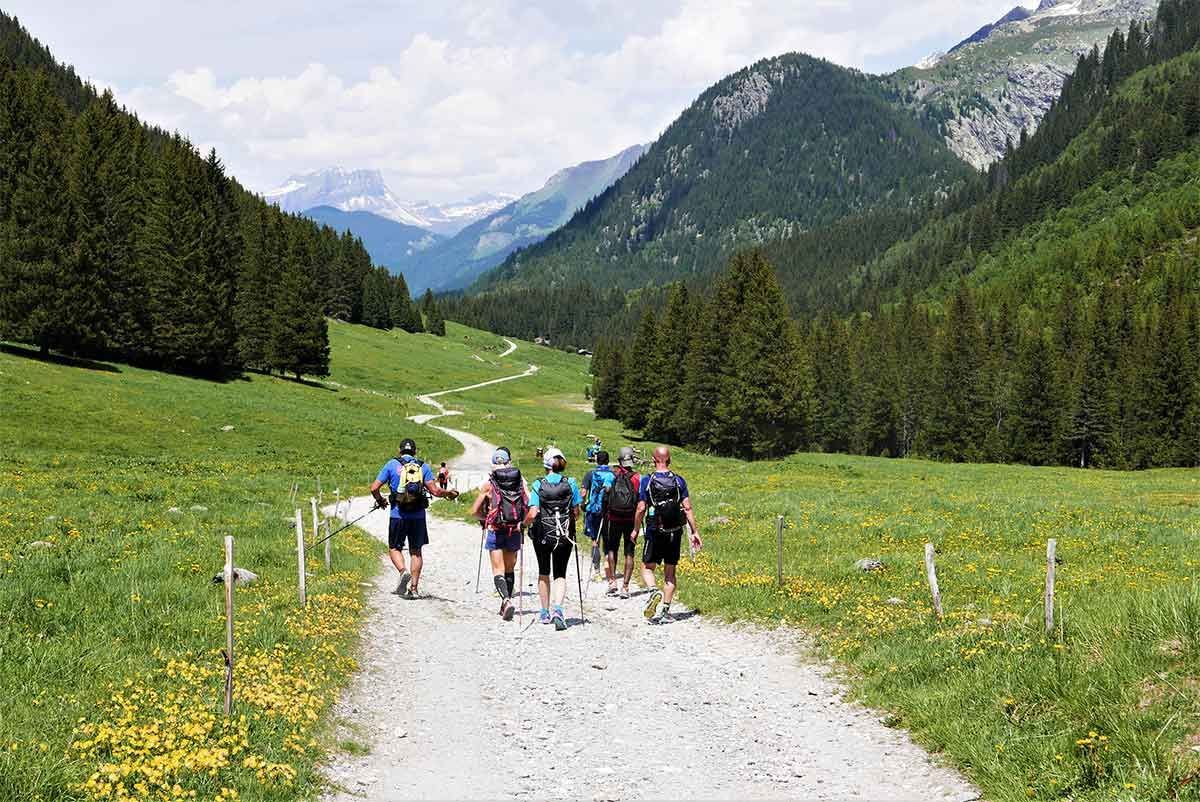 Un groupe de personnes marche sur un chemin de terre dans les montagnes.