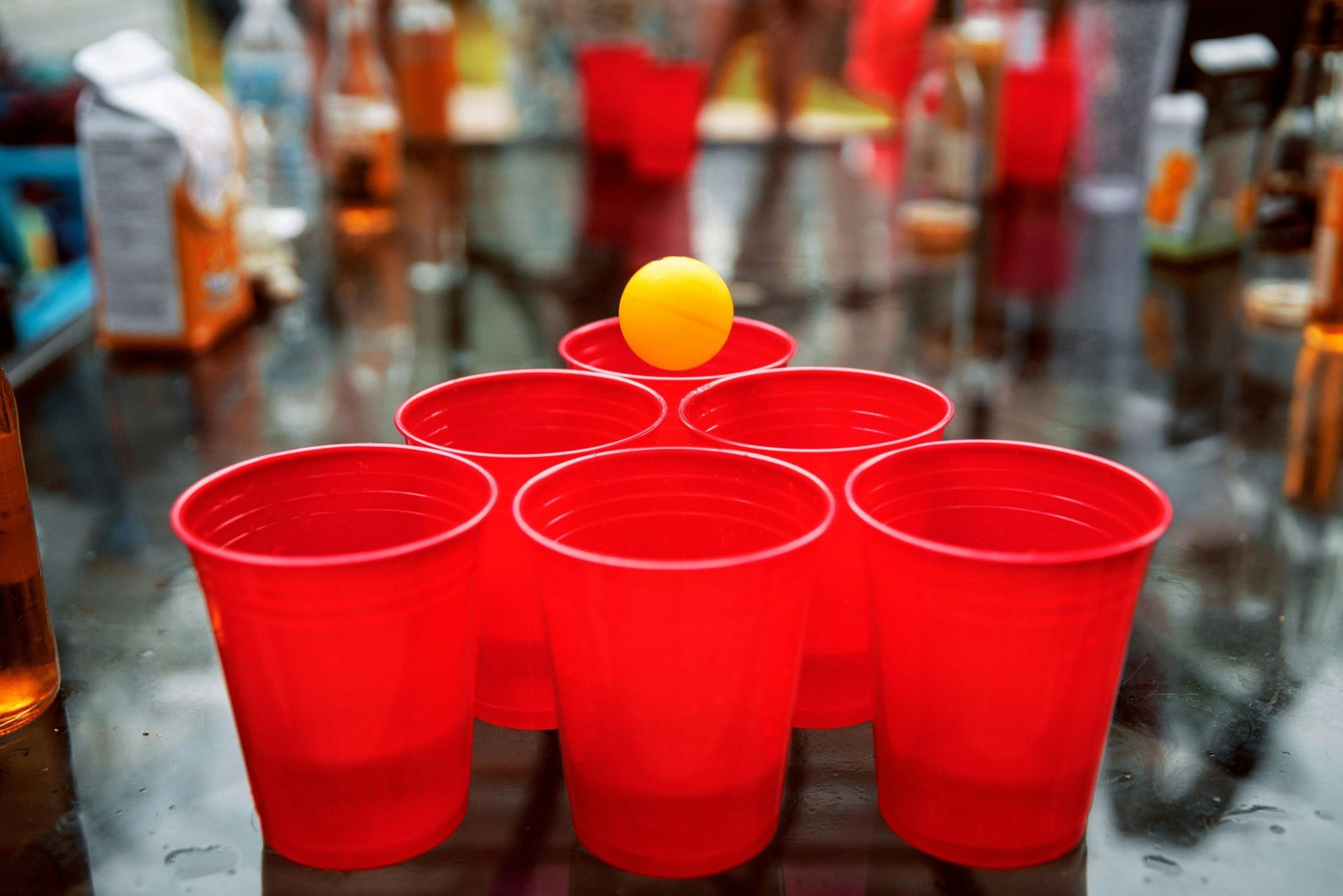 Un tas de gobelets rouges et une boule jaune sur une table.
