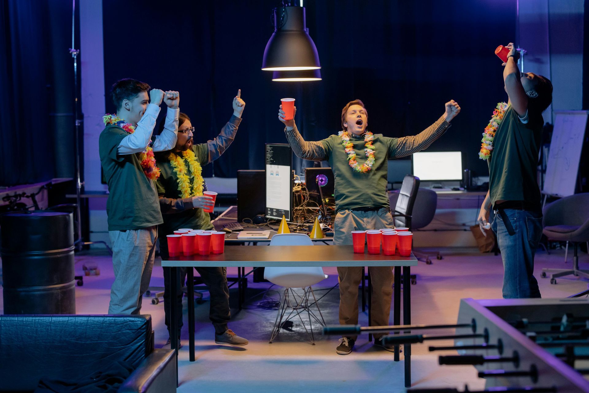 Un groupe de personnes joue au beer pong dans un bureau.