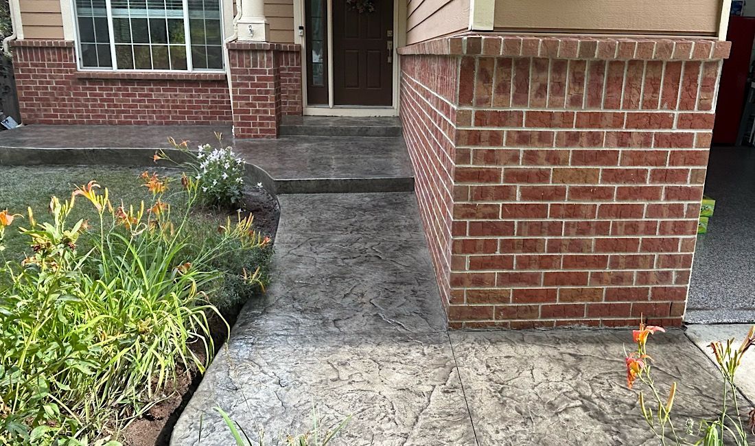 Stamped concrete front walkway with brick columns at a Castle Rock, CO home