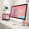 Modern desk with laptop, desktop, and phone showing a pink “Successful online strategy” design