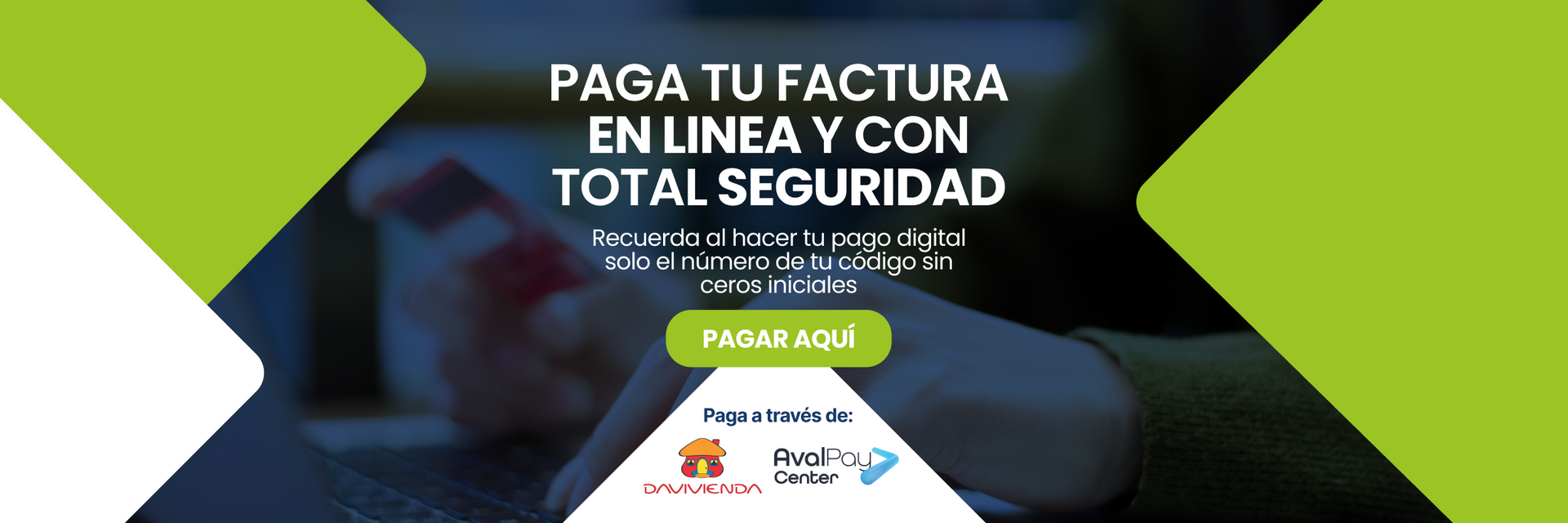 Una persona sostiene un teléfono celular frente a una pantalla de computadora.