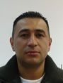 Un hombre que lleva una chaqueta negra y una camisa blanca mira a la cámara.