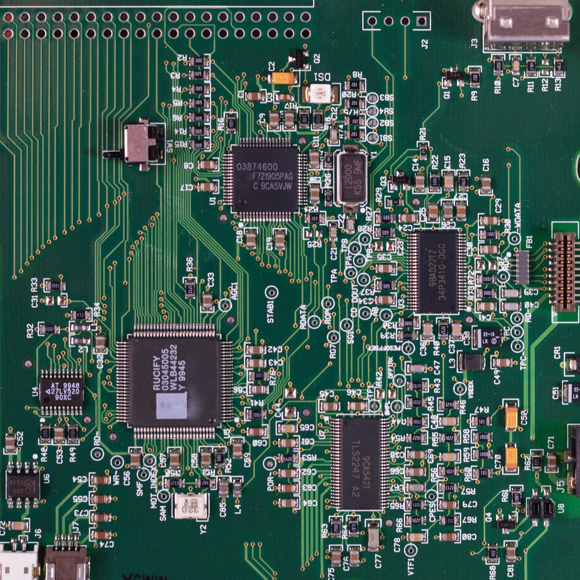 Person applying thermal paste to a computer motherboard, close-up view.