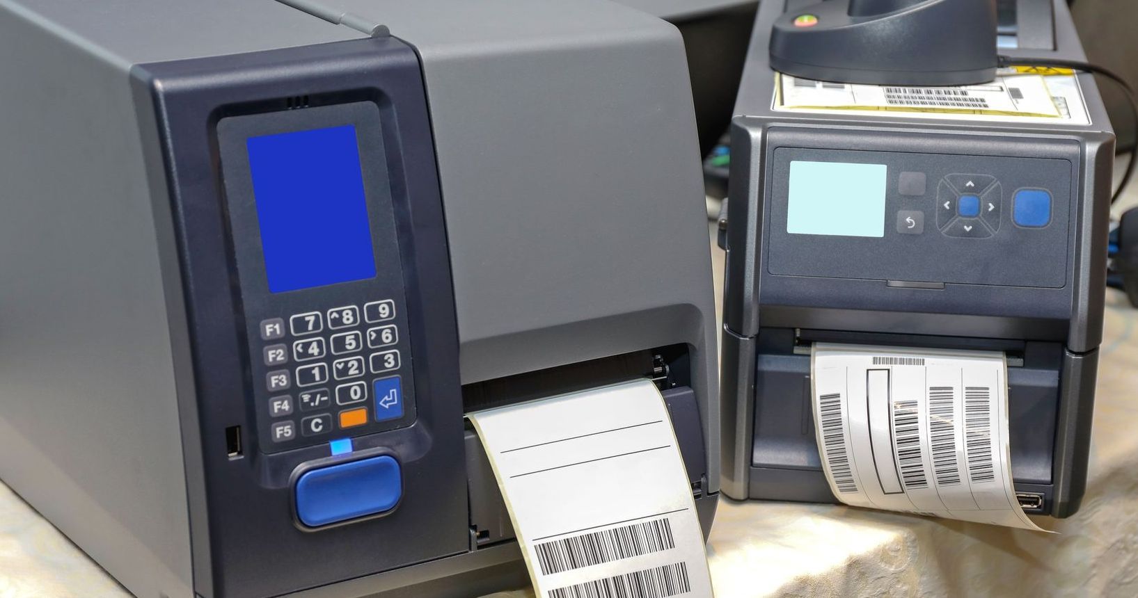 two barcode printers are sitting next to each other on a table .