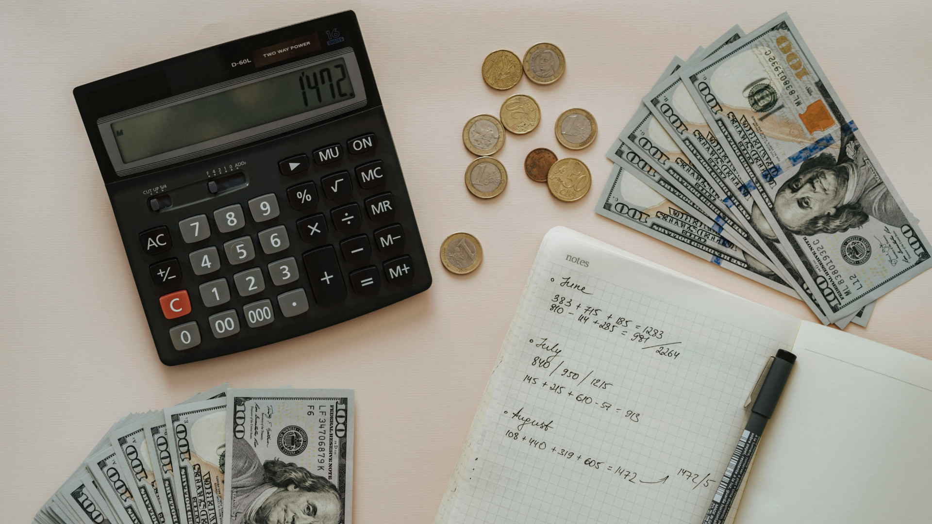 Calculator, coins, cash, and a notepad with pen on a desk for budgeting or accounting