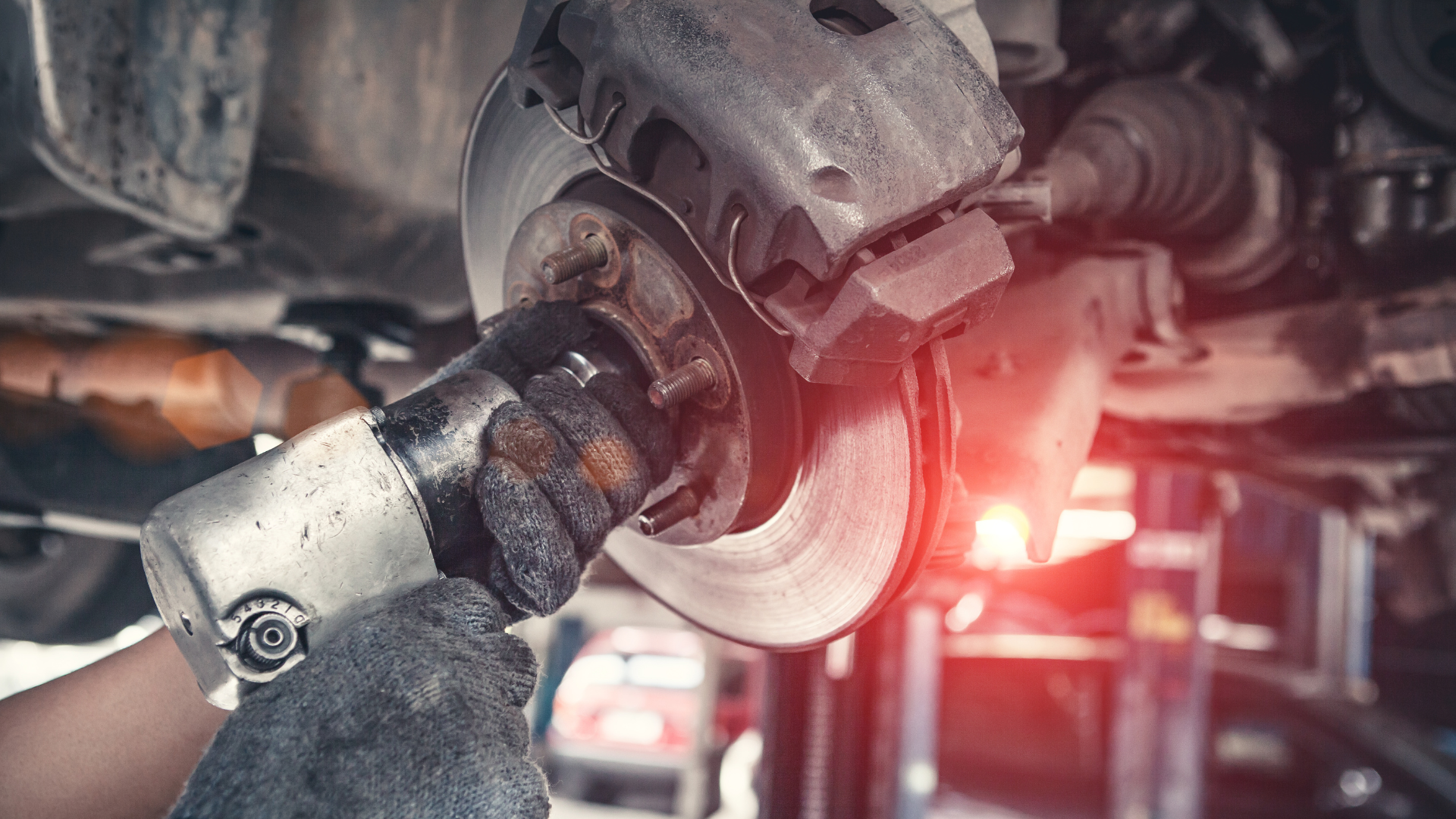 Mechanic grinding a car brake rotor with sparks in an auto repair shop
