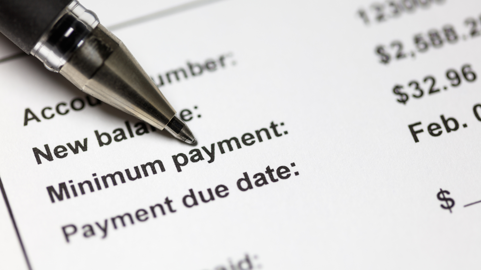 Pen on an account statement highlighting minimum payment and payment due date