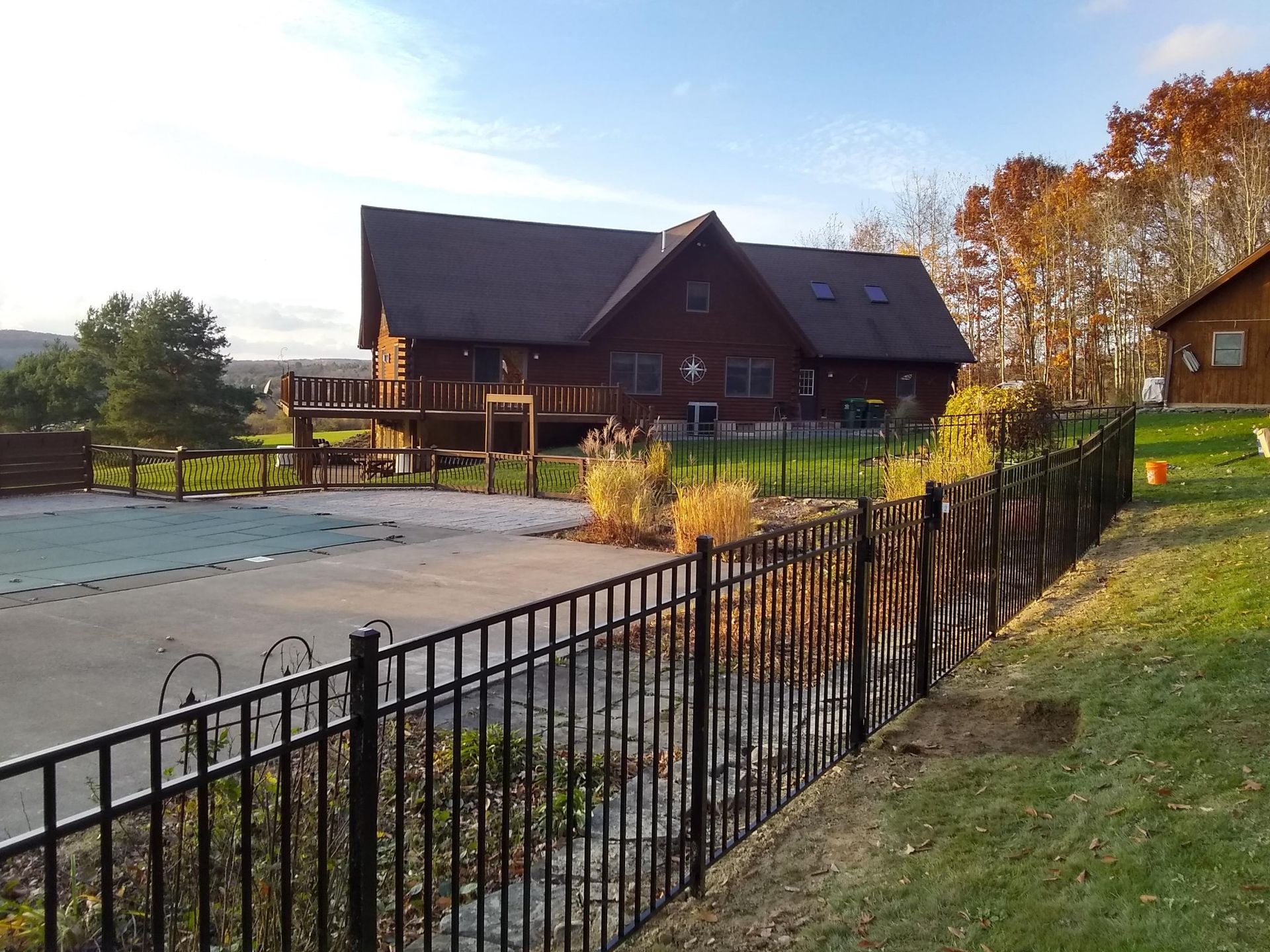 A large house is behind a metal fence