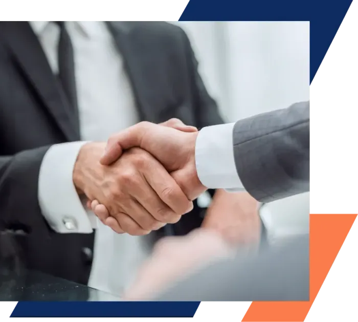 A man in a suit and tie is shaking hands with another man.