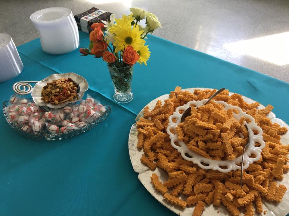 A table topped with plates of food and a vase of flowers.