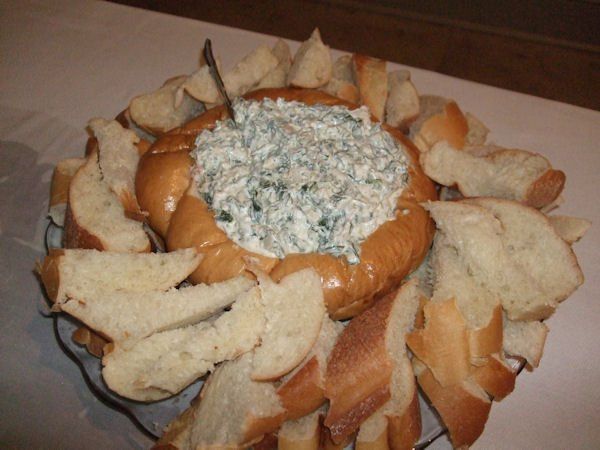 A bowl of dip is surrounded by slices of bread