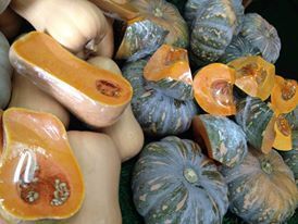 A bunch of pumpkins are sitting on top of each other on a table.