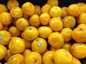 A bunch of oranges are stacked on top of each other in a pile.