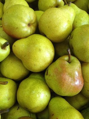 A pile of green pears with red stems