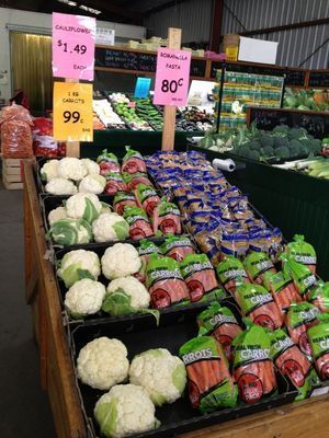 A display of cauliflower and carrots in a grocery store