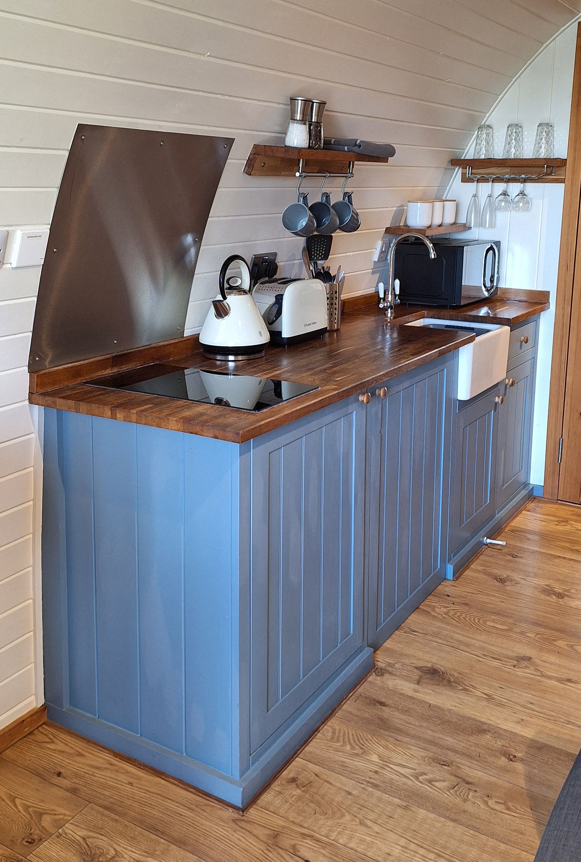 A kitchen with blue cabinets and a white sink