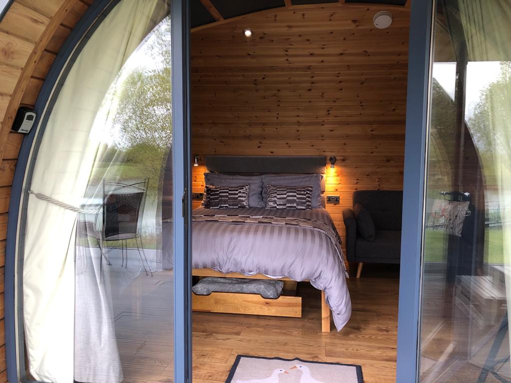 A bedroom with a bed and a sliding glass door.